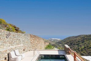 A stone wall, a pool, and a chair. - Sigma Residences Sifnos (Sifnos)