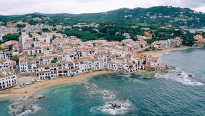 A coastal town with white buildings, a beach, and rocky outcrops in the water. - Apartament amb Espectaculars Vistes al Mediterrani (Palafrugell)