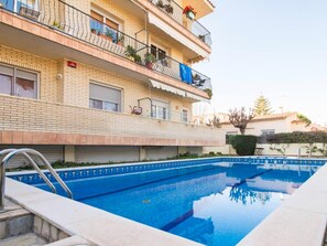 A multi-story apartment building with a swimming pool.