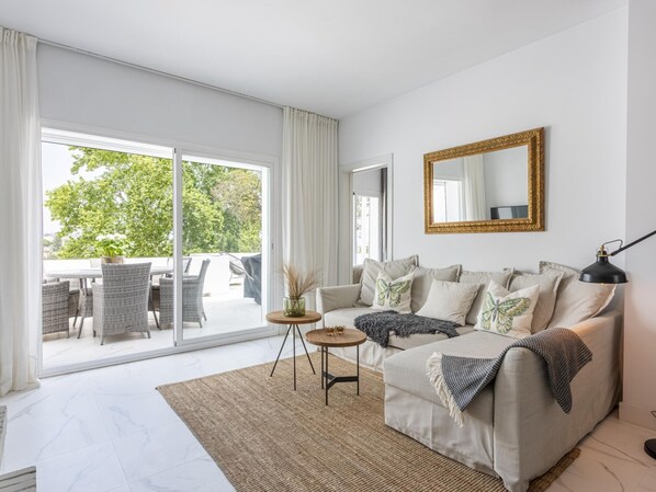 A modern living room with a sofa, a coffee table, and a large window.