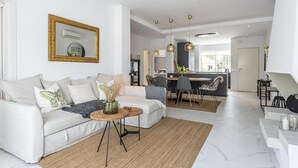 A modern living room with a sofa, coffee table, and dining area. - Contemporary new Apartment With 2 Terraces (Marbella)