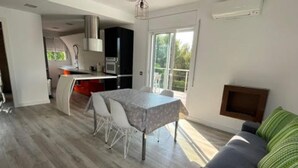 A modern kitchen with a dining area, a sofa, and a TV. - Villa Independiente con Piscina y Vistas (Sant Pere de Ribes)