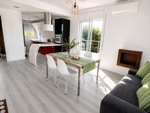 A modern kitchen with a dining area, a sofa, and a TV. - Villa Independiente con Piscina y Vistas (Sant Pere de Ribes)
