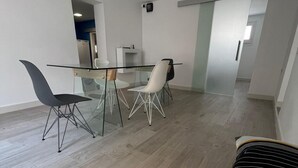 A modern dining area with a glass table, metal chairs, and a wooden floor. - Villa Independiente con Piscina y Vistas (Sant Pere de Ribes)