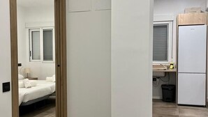 Una habitación moderna con cama, una mesita de noche y una ventana con persianas.