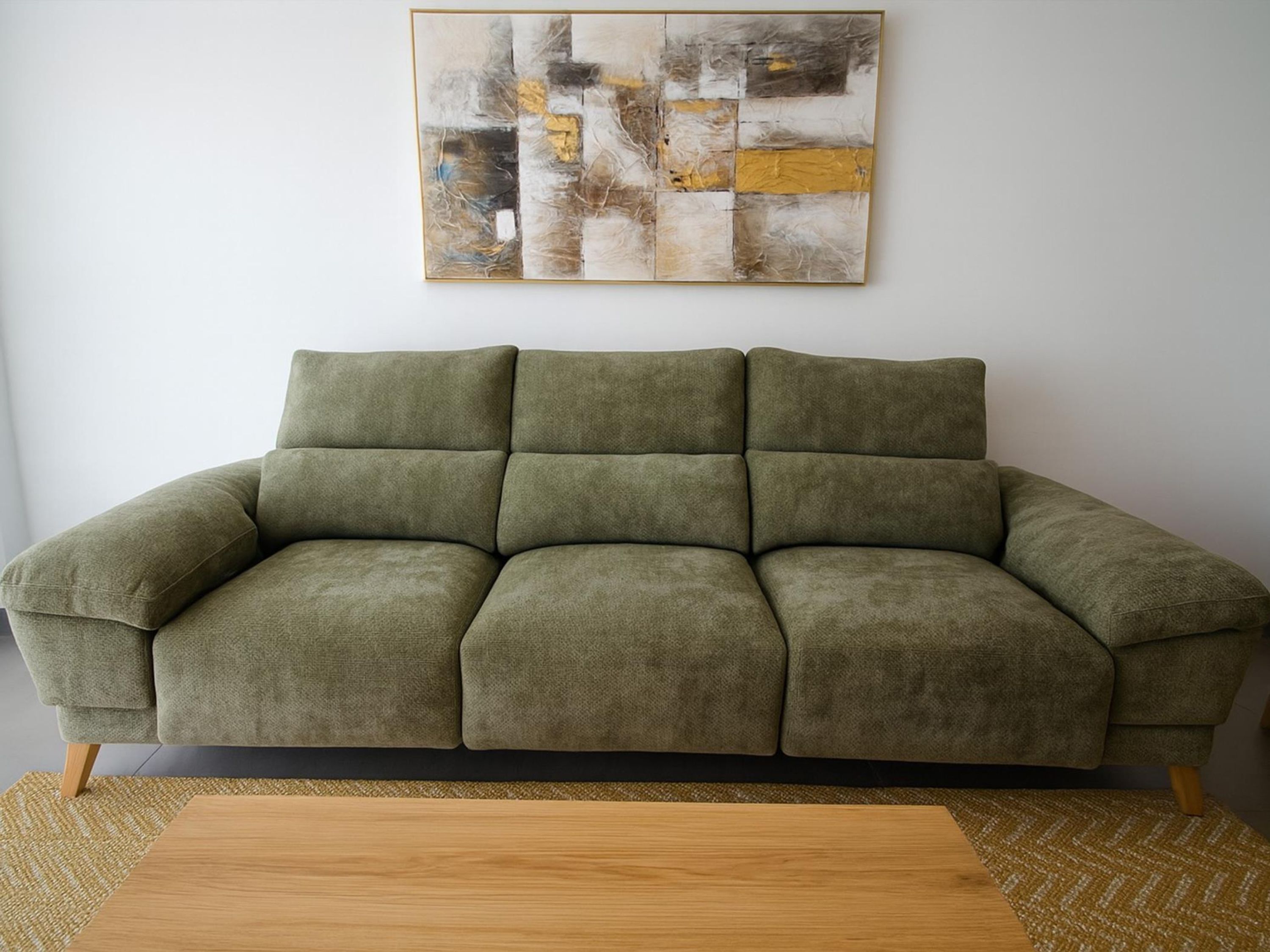 Un sofá verde con una mesa de centro de madera.