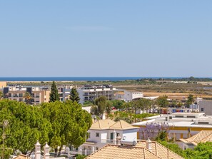 Ein Küstenwohngebiet mit modernen Gebäuden, blauem Himmel und Blick auf das Meer.