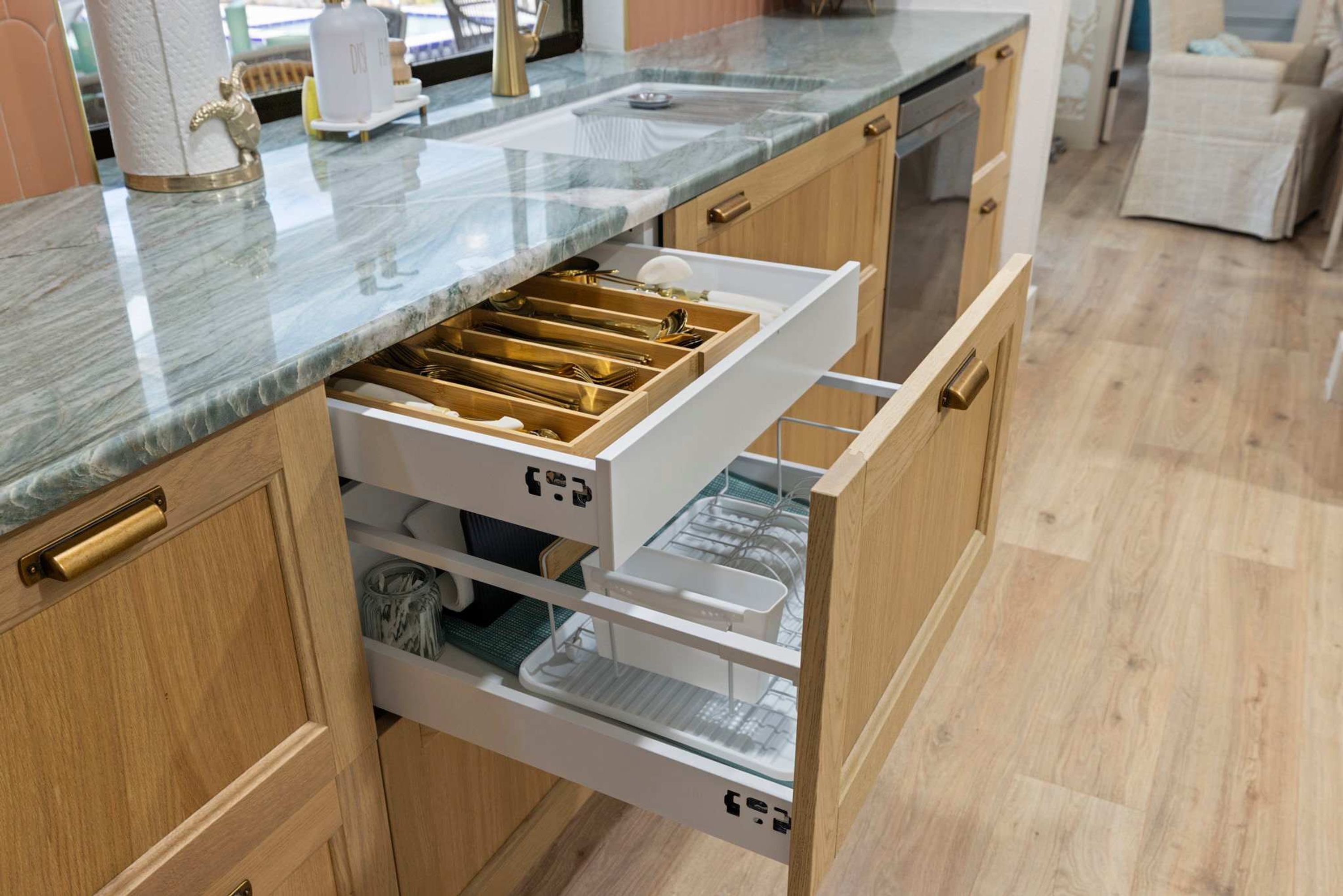 Una cocina con encimera de mármol, armarios de madera y lavavajillas integrado.