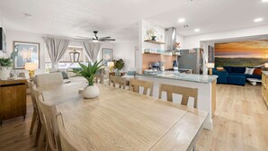 Un soggiorno moderno con angolo ristoro, cucina e zona salotto.
