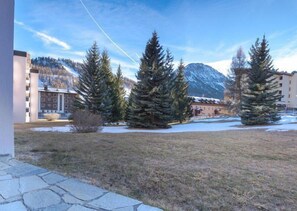 A courtyard with snow-covered ground, evergreen trees, and buildings in the background. - 50m from ski slopes, Ground floor, view mountain, parking, tv, ski locker, 18m², Montgenèvre (Montgenèvre)