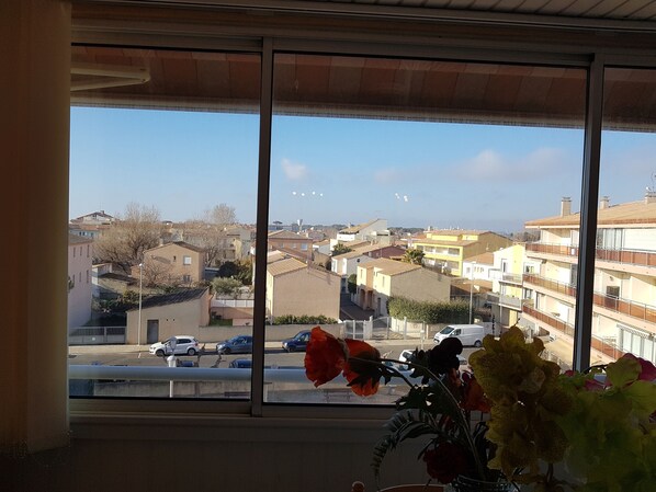 A view from a window overlooking a residential area with houses and parked cars.