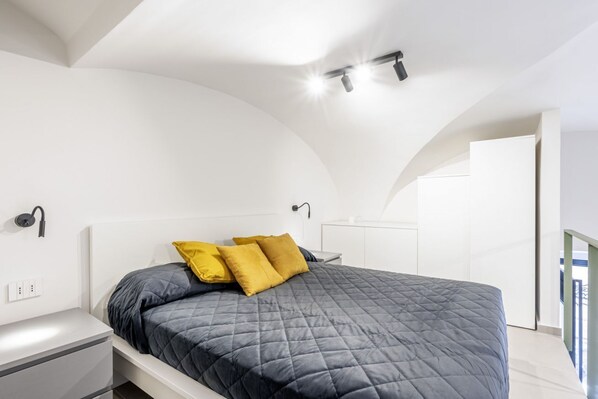 A modern bedroom with a bed, bedside tables, and a nightstand.