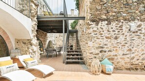 A pool area with lounge chairs, a staircase, and stone walls. - Garriguella- Roses Pool Costa Brava House (Garriguella)