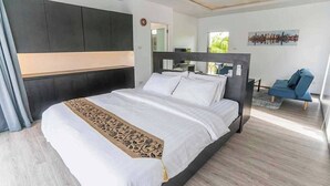A modern bedroom with a large bed, dark headboard, and a cityscape view. - The wide view resort cafe (Thep Krasattri)