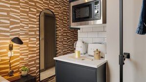 Une cuisine moderne équipée d’un four à micro-ondes, d’un grille-pain et d’une machine à café, le tout posé sur le plan de travail.