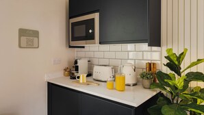 Eine Küche mit Mikrowelle, Toaster, Wasserkocher und einem QR-Code an der Wand.