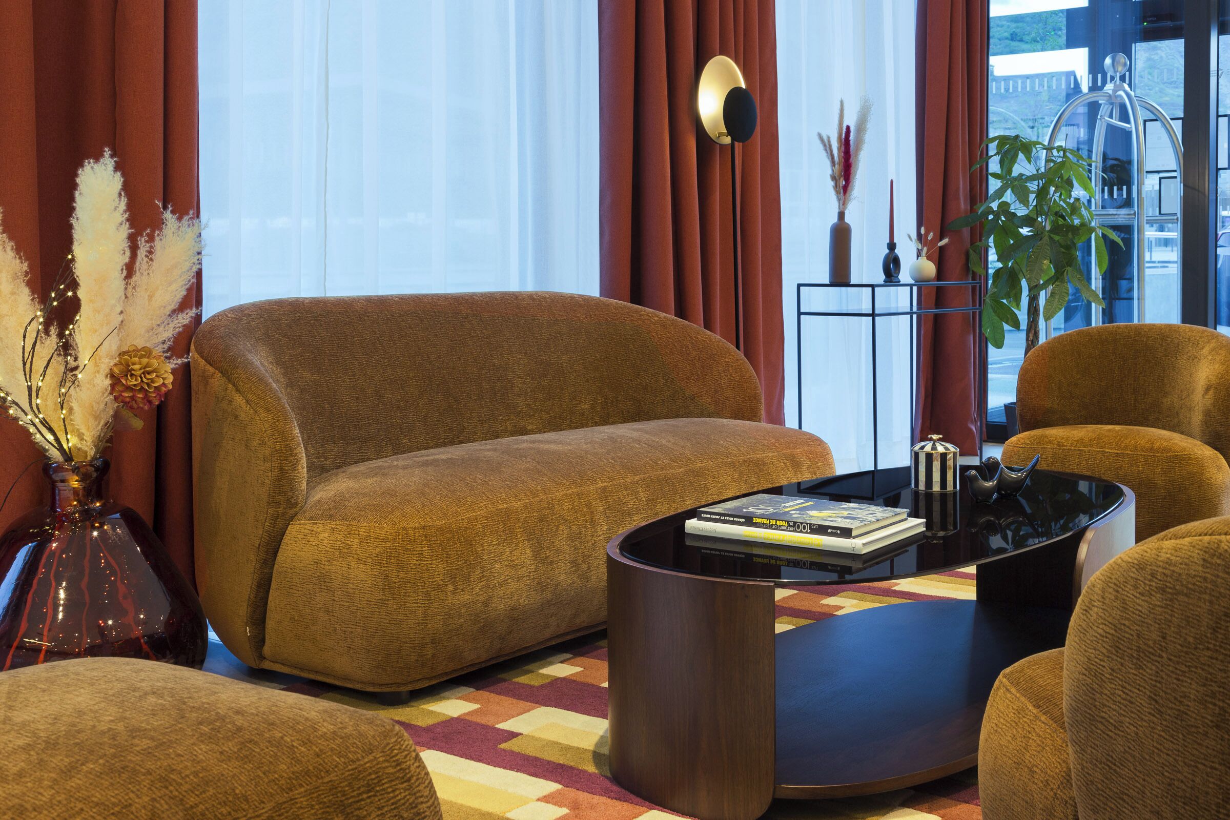 Una sala de estar con un sofá, sillones, una mesa de centro y una estantería.