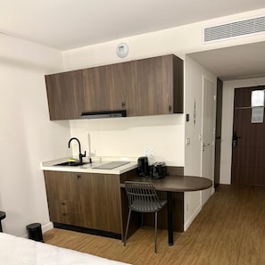 A compact kitchen with a sink, a coffee maker, and a toaster. - Nehô Suites St Jean de Maurienne (Saint-Jean-de-Maurienne)