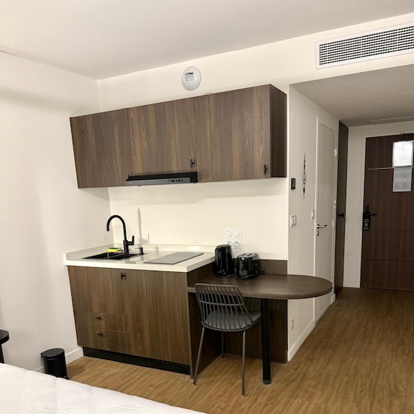 A compact kitchen with a sink, a coffee maker, and a toaster. - Nehô Suites St Jean de Maurienne (Saint-Jean-de-Maurienne)