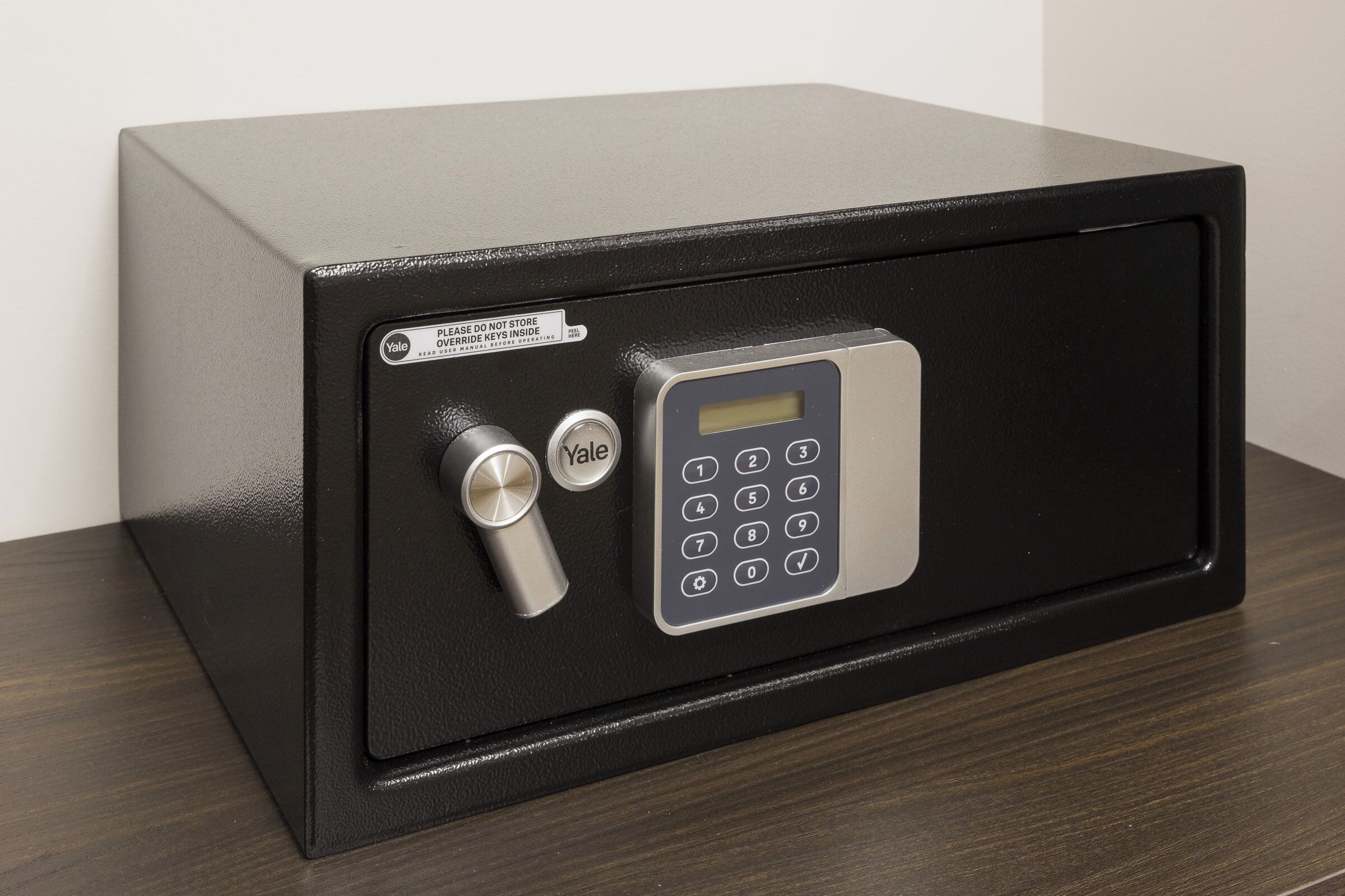 A black safe with a keypad and a combination lock.