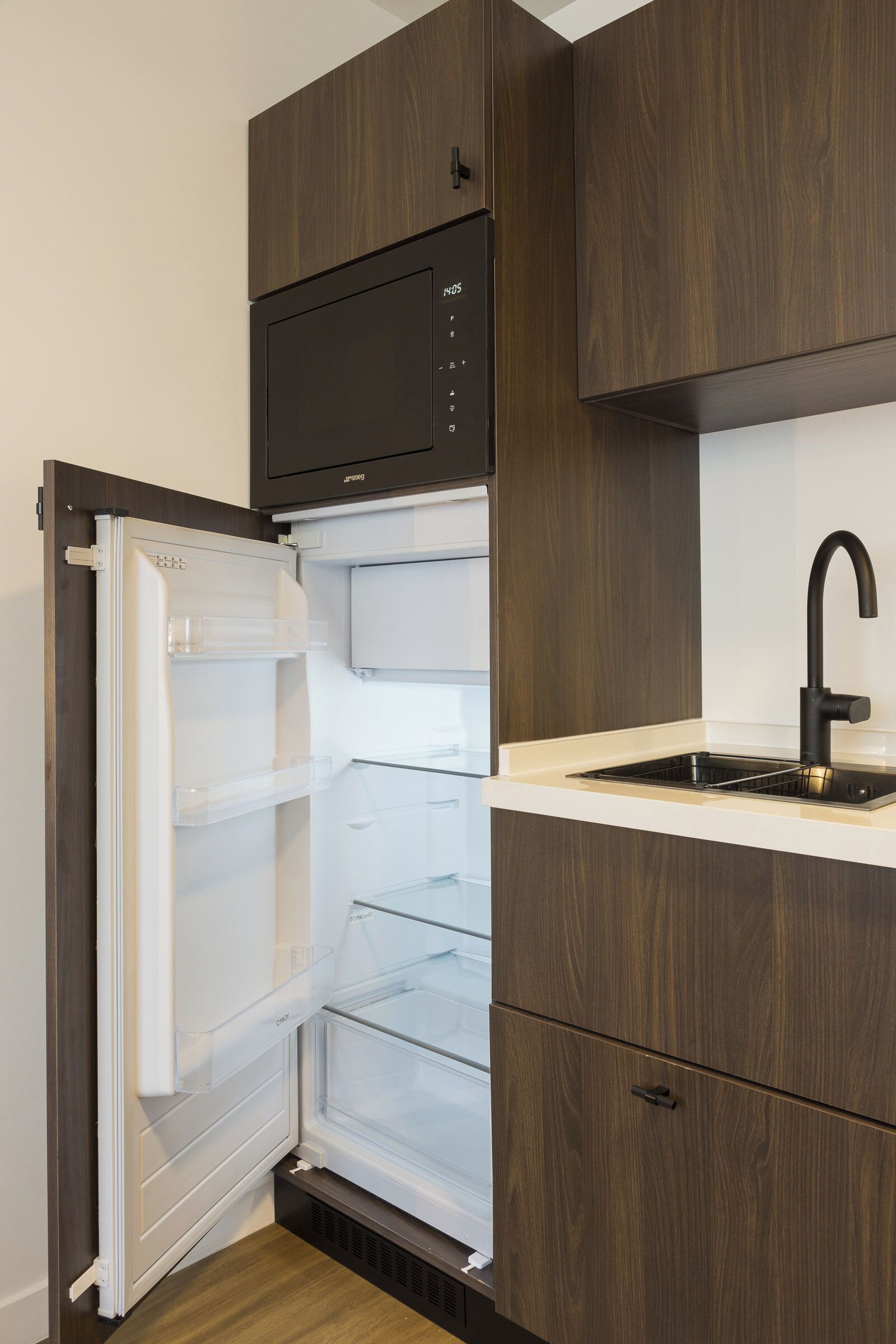 A modern kitchen with a built-in refrigerator, a microwave, and a sink.