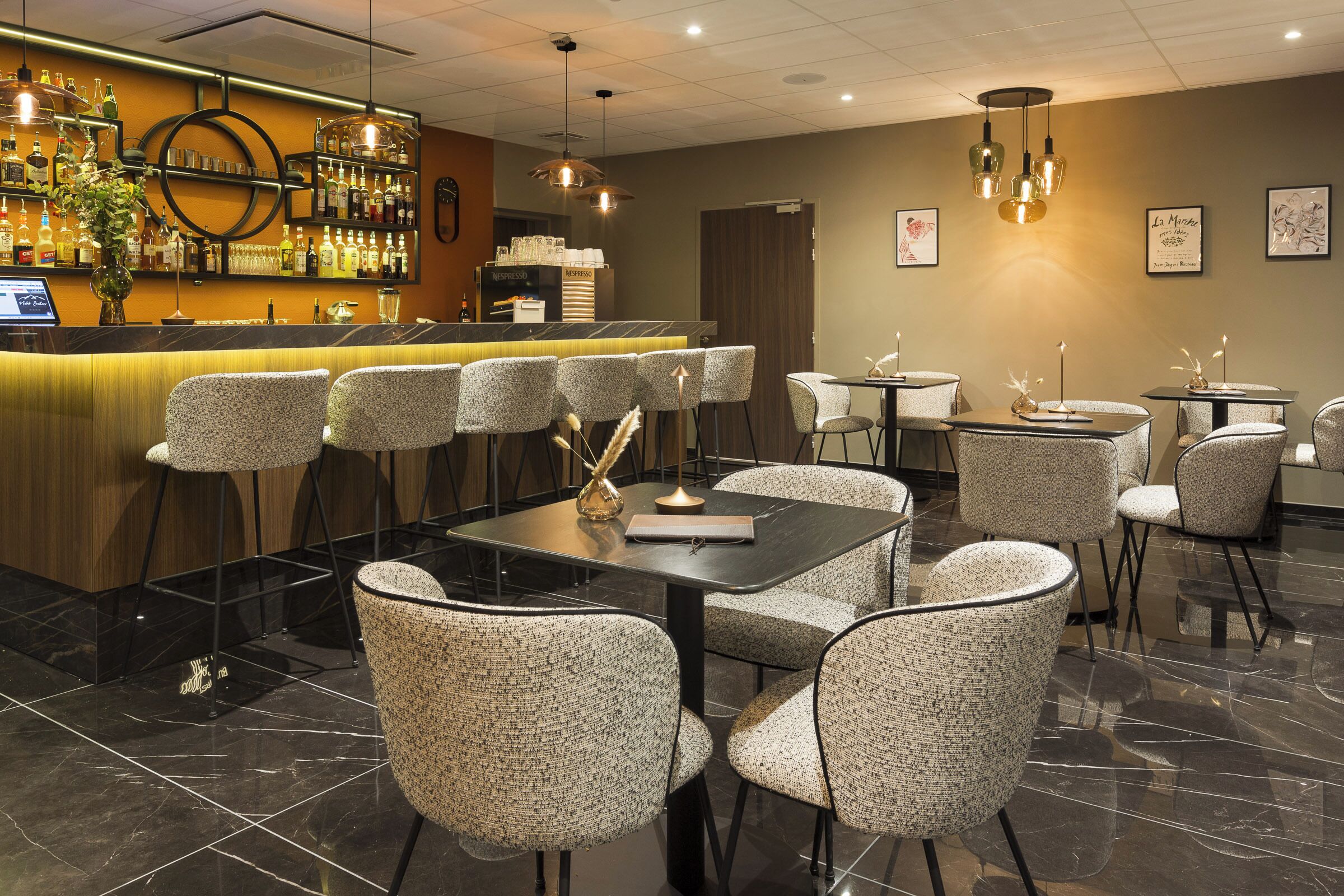 A restaurant interior with a bar area, seating arrangements, and a modern design.
