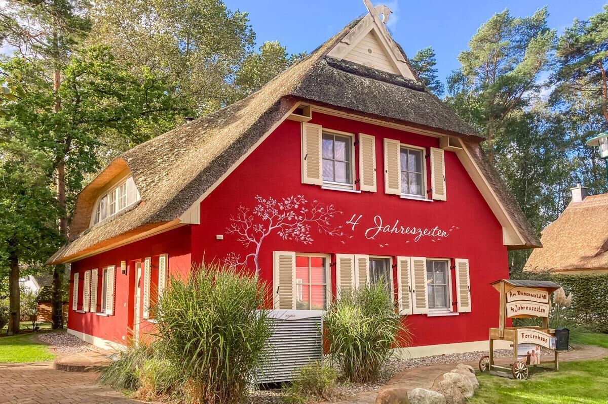 A red building with a thatched roof and a sign reading "4 Jahreszeiten".