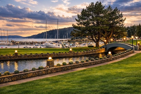 A marina with boats, a stone bridge, and a well-maintained grassy area.