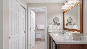 A bathroom with a double sink, a large mirror, and a towel rack. - Bayside Waterfront King_Ocean Views_King Bed_Pool (Eastsound)