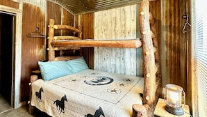 Un dormitorio rústico con cama, cabecera de madera y ventilador de techo.