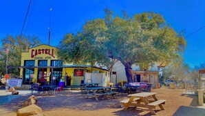 Una tienda general llamada CASTELL con mesas y sillas al aire libre.