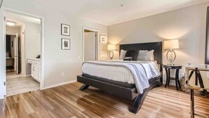 A modern bedroom with a large bed, bedside tables, and a walk-in closet.