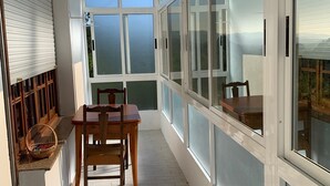 A sunlit room with a dining table and chairs, large windows, and a view of the outdoors. - Carpenter's house (Crecente)