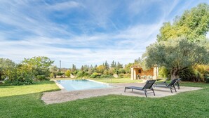 Una piscina con sillas de descanso y un patio de ladrillo.