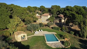 Une villa dotée d’une piscine, d’une architecture en pierre et d’un jardin luxuriant.