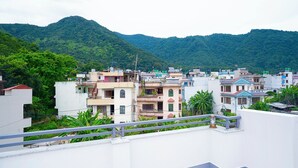 A residential area with multi-story buildings, a mountainous backdrop, and a clear sky. - Peaceful 2BHK Retreat | Near Forest Reserve (Kathmandu)