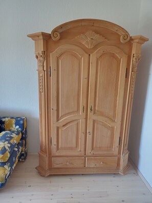 Ein hölzerner Kleiderschrank mit zwei Türen und verzierten Schnitzereien.