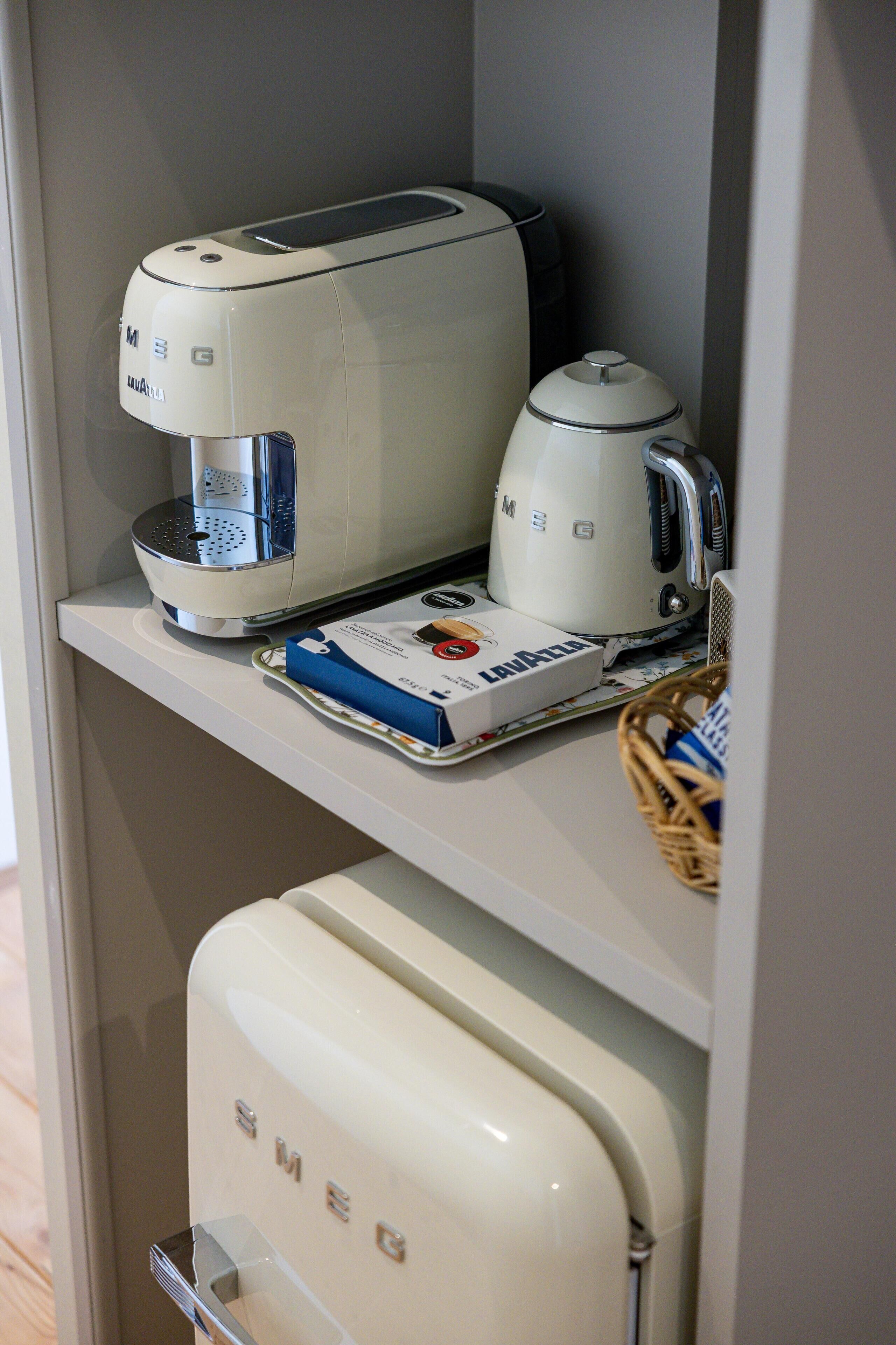 A kitchen area with a coffee maker, a toaster, and a box of Lavazza coffee.