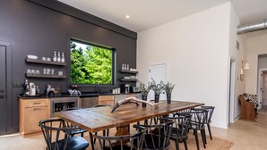 Una cocina moderna con un amplio ventanal, una mesa de madera y sillas.