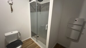 A bathroom with a toilet, a glass shower enclosure, and a white towel rack. - Le Boheme, studio 2p (Lens)