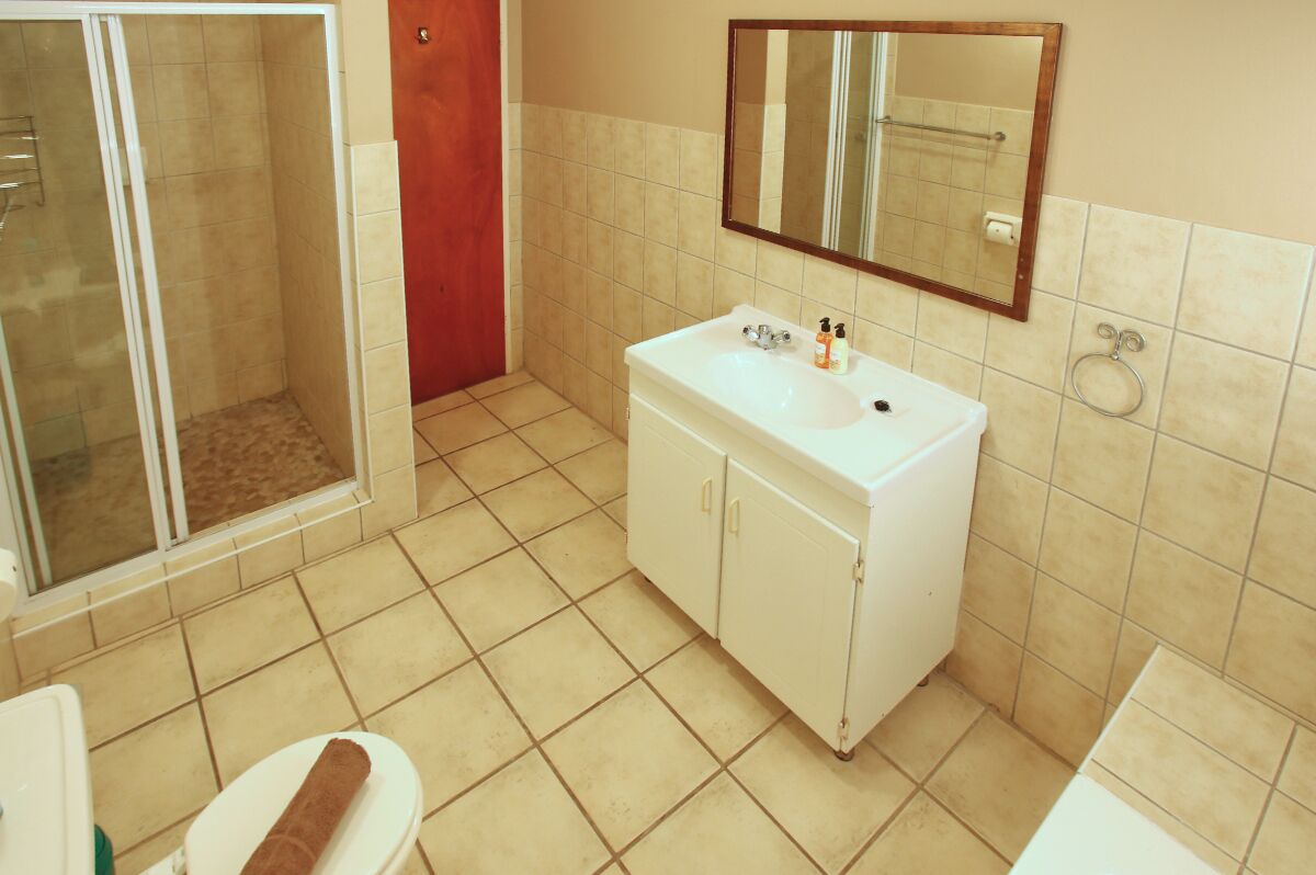 Un baño con ducha, inodoro, lavabo y espejo.