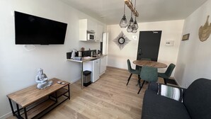 A compact living space with a kitchenette, a dining area, and a seating area.