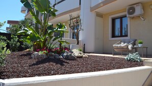 Un bâtiment moderne doté d’un balcon, d’une chaise et d’une plante en pot.