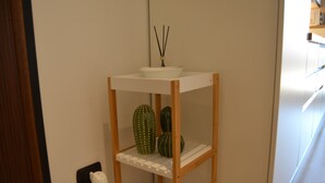 Une étagère blanche avec un bol blanc et deux vases décoratifs.