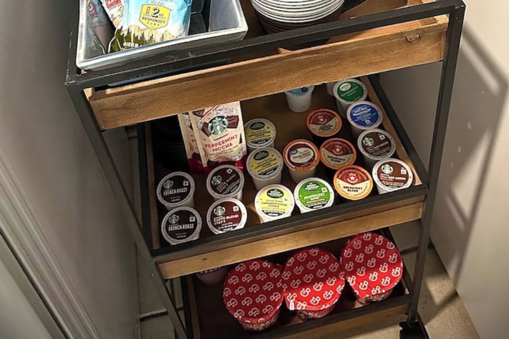 A storage cart with various coffee containers and a bag of Starbucks coffee.