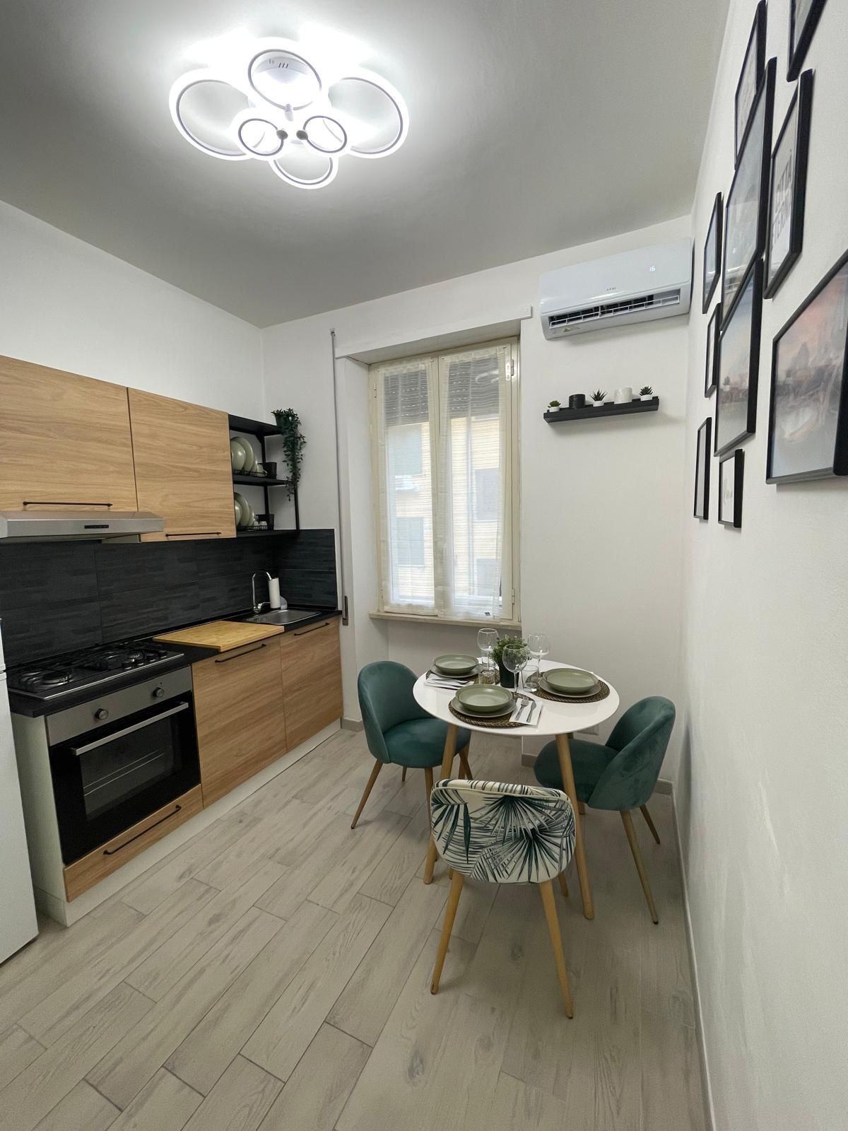 A modern kitchen with a dining area, featuring a stove, oven, and wooden cabinets.