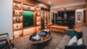 A modern living room with a built-in bookshelf, a round coffee table, and a sofa. - Rooftop Pool Oasis in Roma Norte w/ Gym & A/C (Mexico City)
