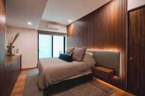 Une chambre à coucher moderne avec un lit, une table de chevet et une fenêtre.