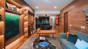 A modern interior with a wooden wall, a dining area, and a seating area with a sofa and a coffee table. - Rooftop Pool Oasis in Roma Norte w/ Gym & A/C (Mexico City)