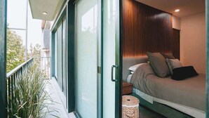 A modern bedroom with a bed, bedside table, and a small round wicker basket. - Rooftop Pool Oasis in Roma Norte w/ Gym & A/C (Mexico City)